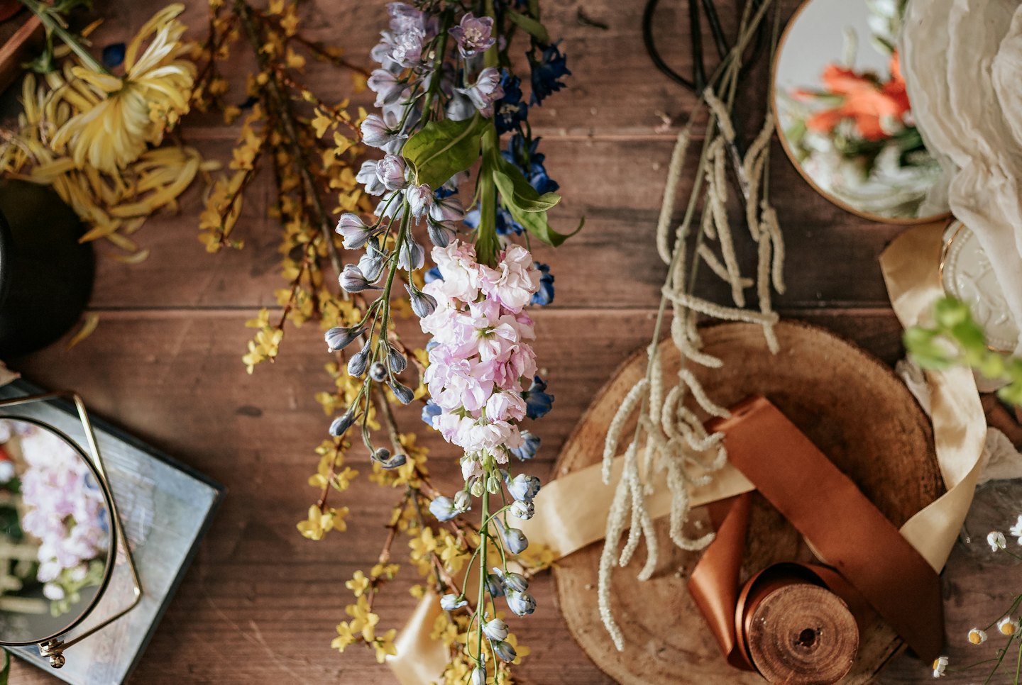 Blomsterhandelns förnödenheter och färska blommor arrangerade på ett rustikt bord.